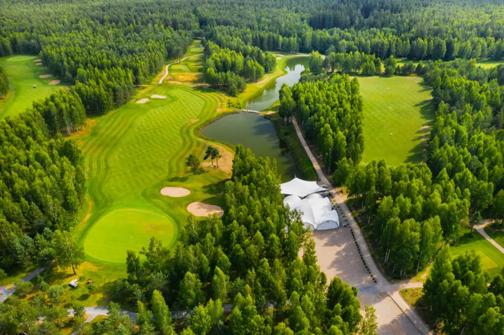 Top view of the golf course located in a wooded area