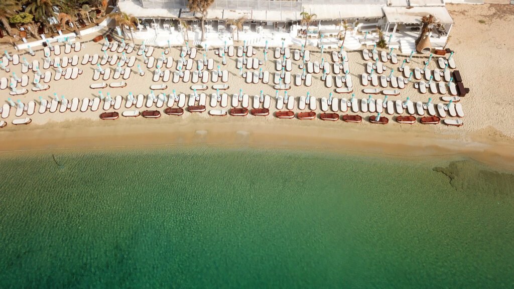 Aerial view of clear water and organized beach at Psarou on Mykonos