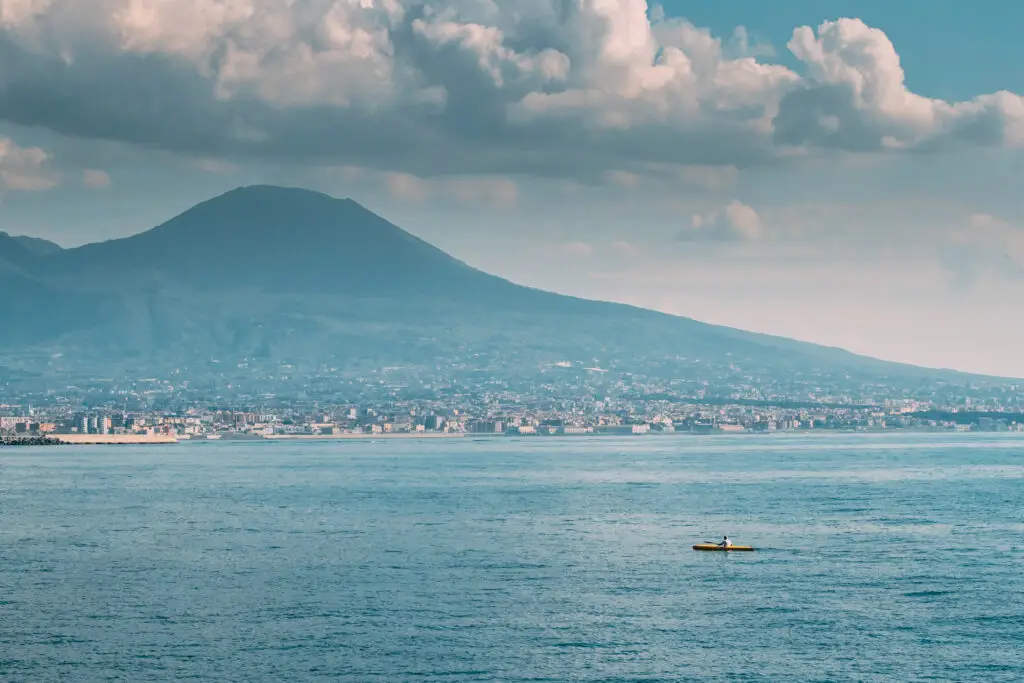 Small vessel on the Bay of Naples with coastal and volcanic landscape context