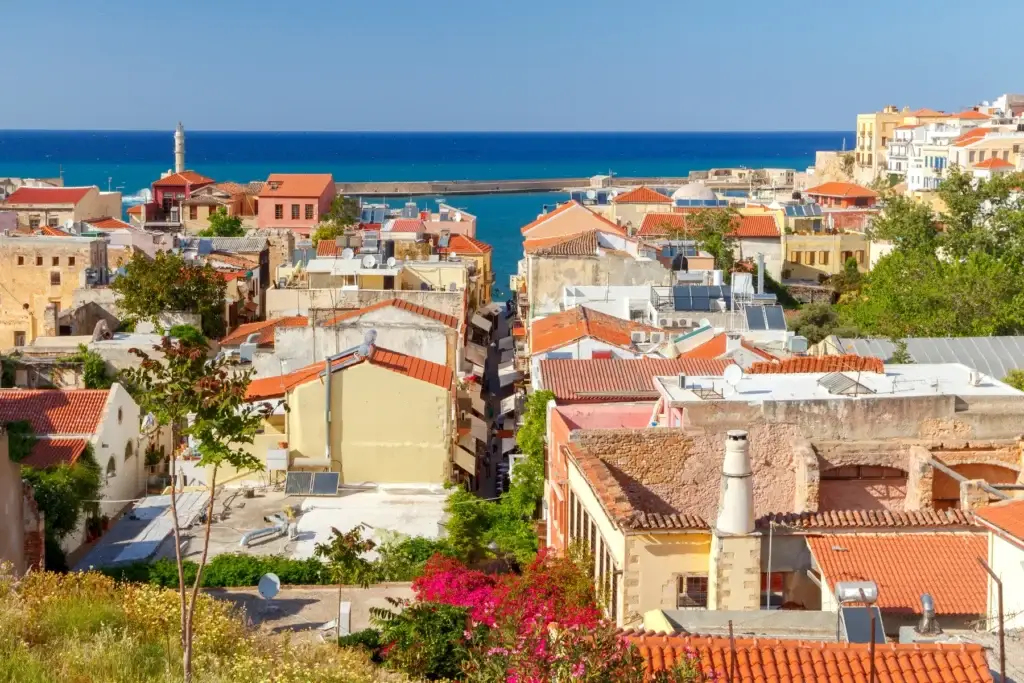 Aerial view across Chania's tiled roofs toward the sea in Crete