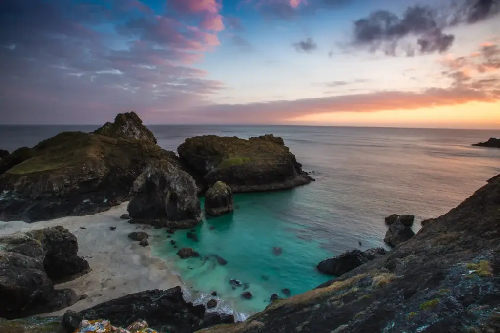 Kynance Cove and turquoise water at sunset in Cornwall