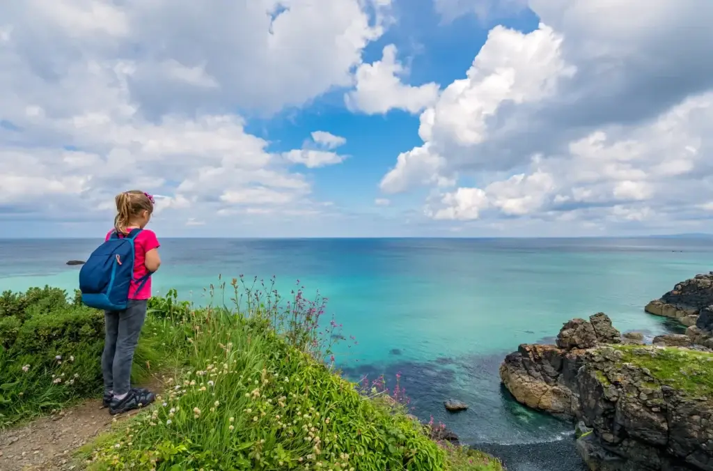 Girl with a backpack on the Cornish coast