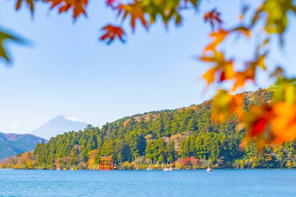 Lake Ashi in Hakone framed by autumn leaves with Mount Fuji beyond