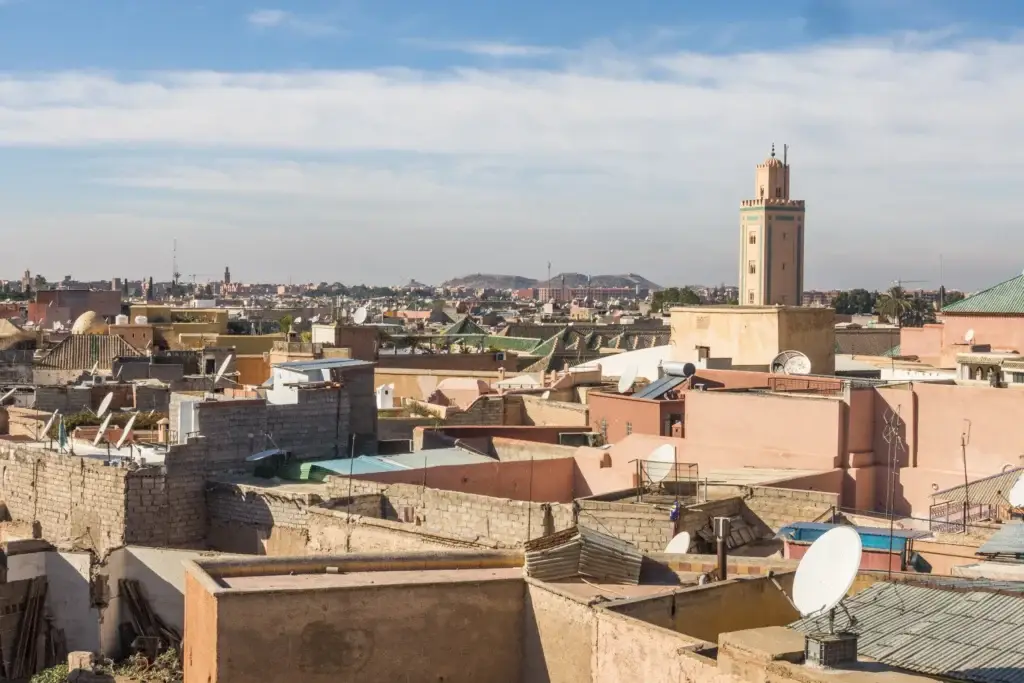 Marrakech Medina rooftops and minaret beneath a broad blue sky