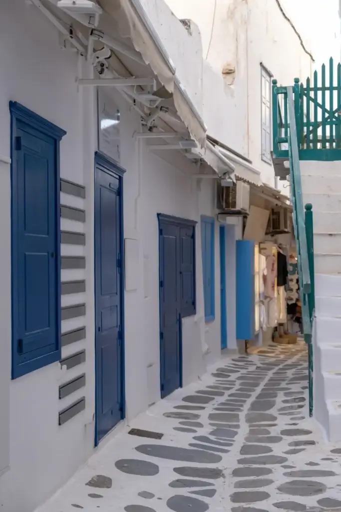 Whitewashed cobblestone lane with blue details in Chora, Mykonos