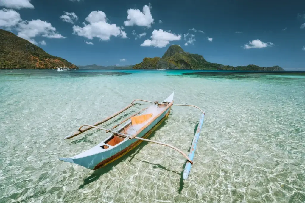 Traditional banca boat in shallow water before Cadlao Island in Palawan