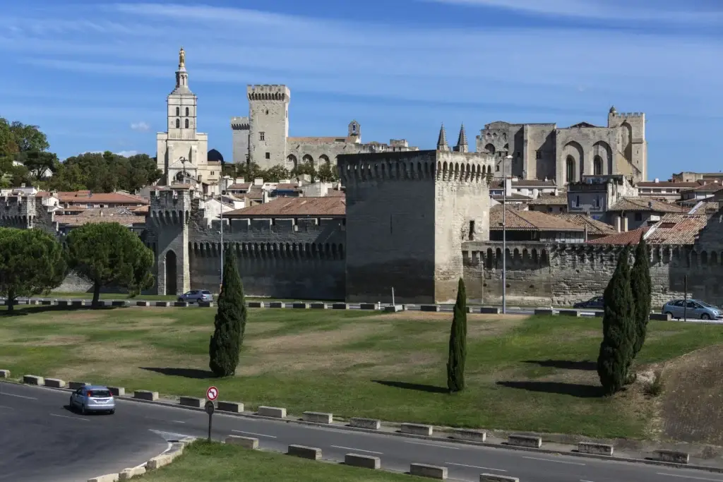 Historic walls and towers of Avignon under a blue sky