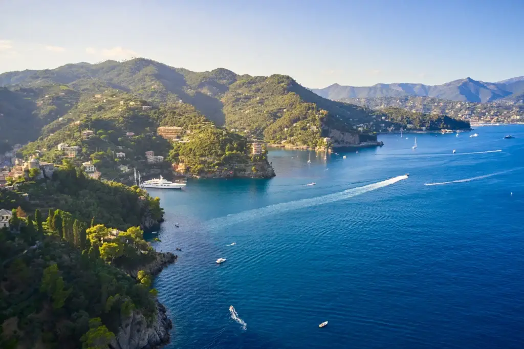 Yachts and boats are sailing in the Ligurian Sea on the mountain background, Portofino, Italy. Rocks