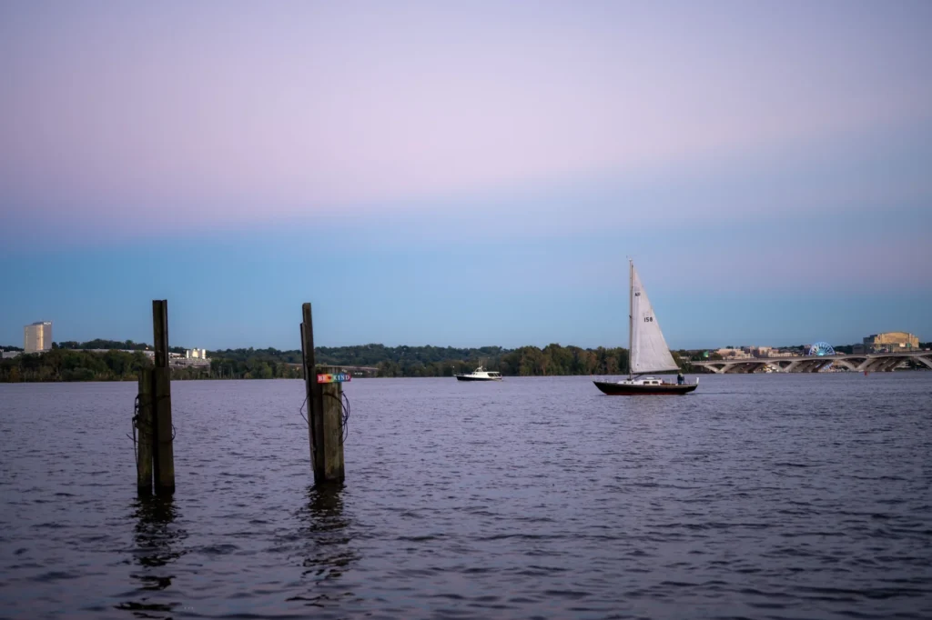 Aerial view of boat sailing on sea during sunset