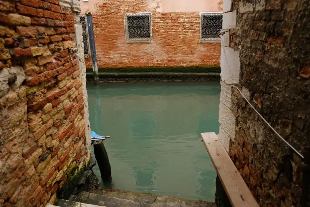 Quiet residential canal between historic brick buildings in Venice