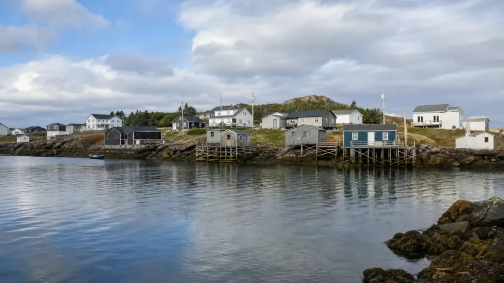 Change Islands harbour or settlement with recognizable fishing stages, homes and tickle geography