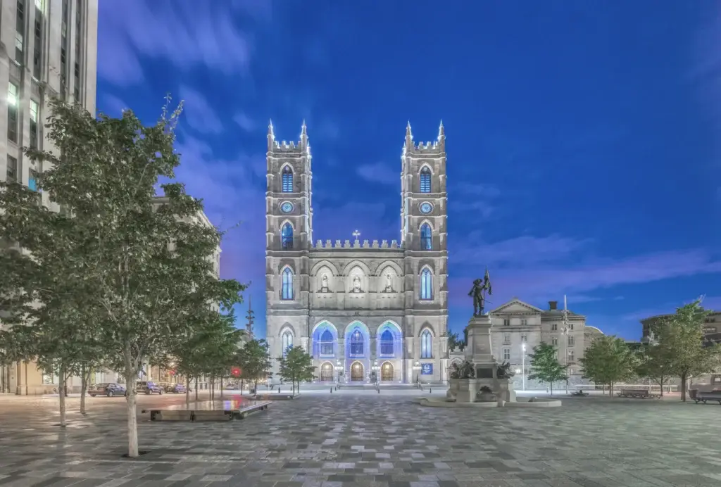 Old Montréal cobblestone streetscape, Place d'Armes or Notre-Dame Basilica exterior in exact context