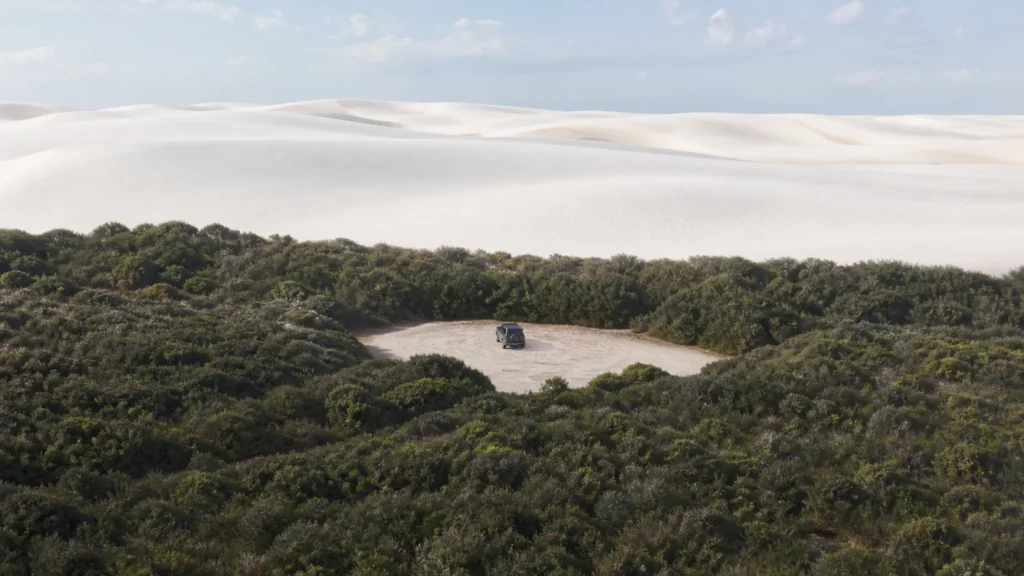 AI-generated editorial visualization of regulated visitor scale in Lencois Maranhenses; it does not document a licensed operator, route or current access.