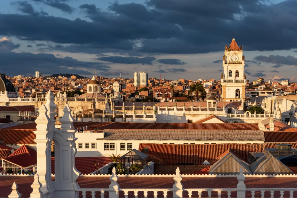 Documented Sucre cityscape or precise two-city editorial composition