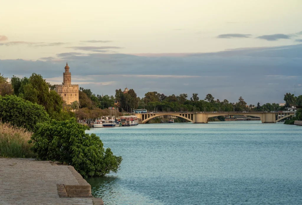 Guadalquivir riverfront with Torre del Oro and San Telmo Bridge, Seville.