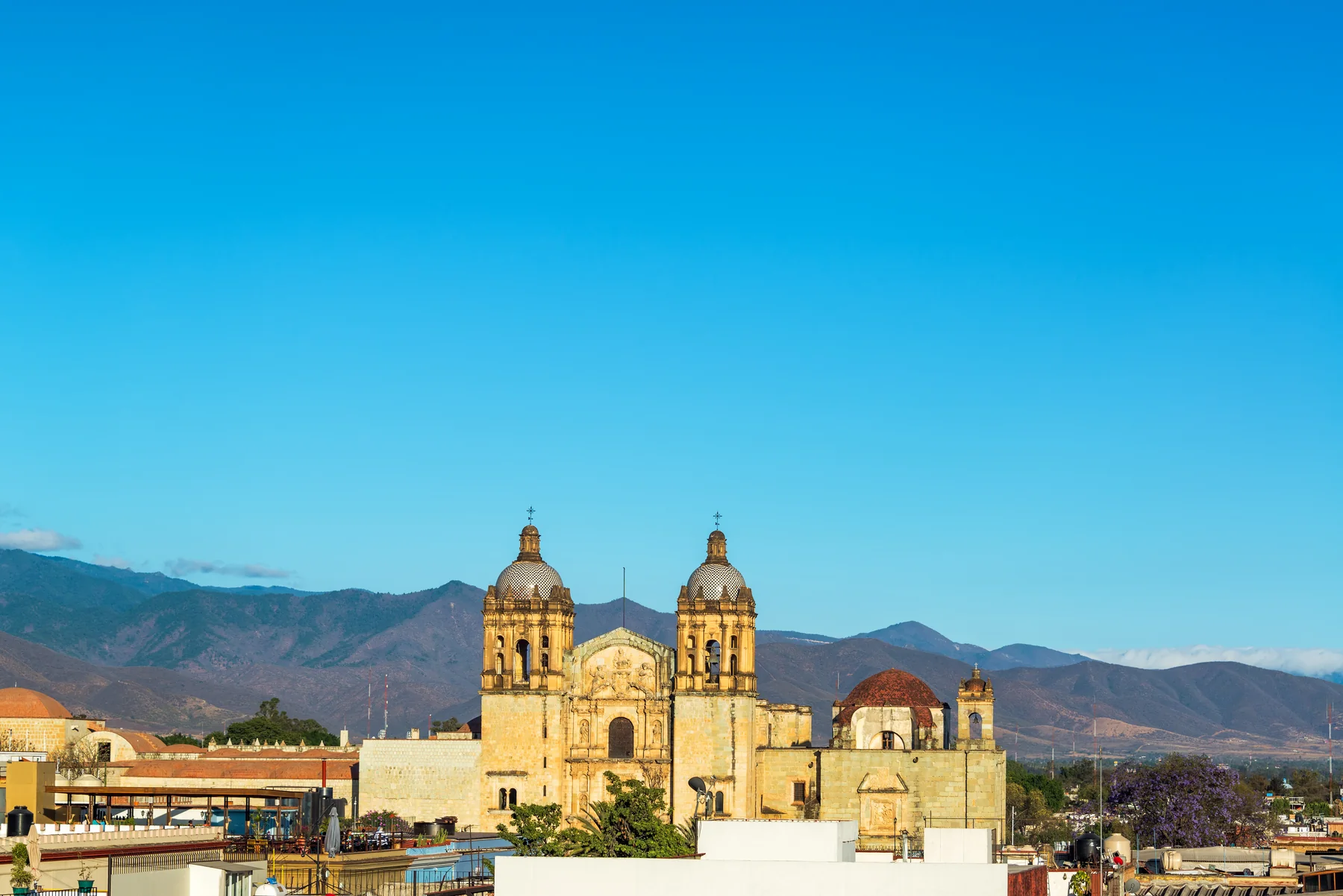 Santo Domingo Church In Oaxaca, Mexico With Hills Rising In The Background