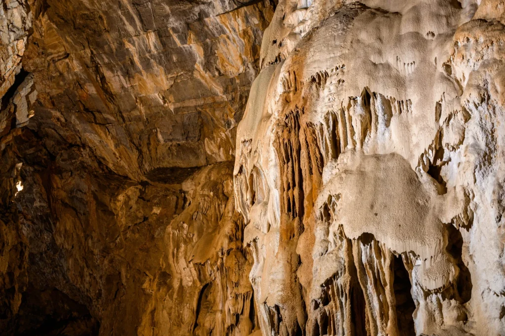 Formations of stalactites and stalagmites around a path inside a karst underground cave
