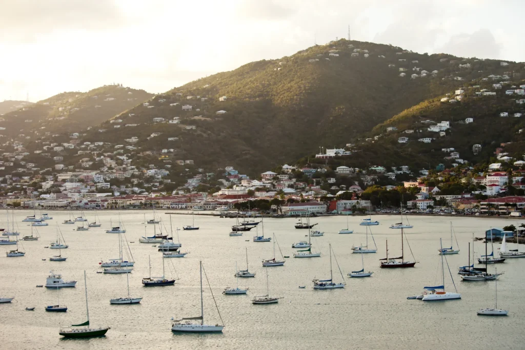Sailboats Moored near Town by Lush Green Hills