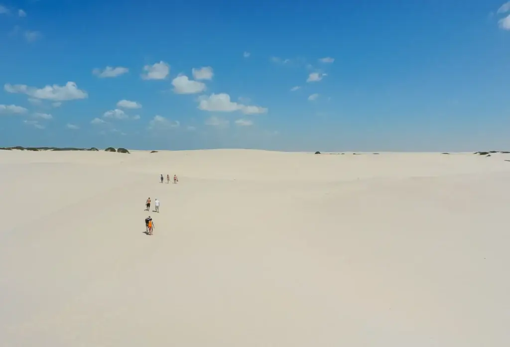 Walkers provide scale among the dunes of Lençóis Maranhenses near Barreirinhas.