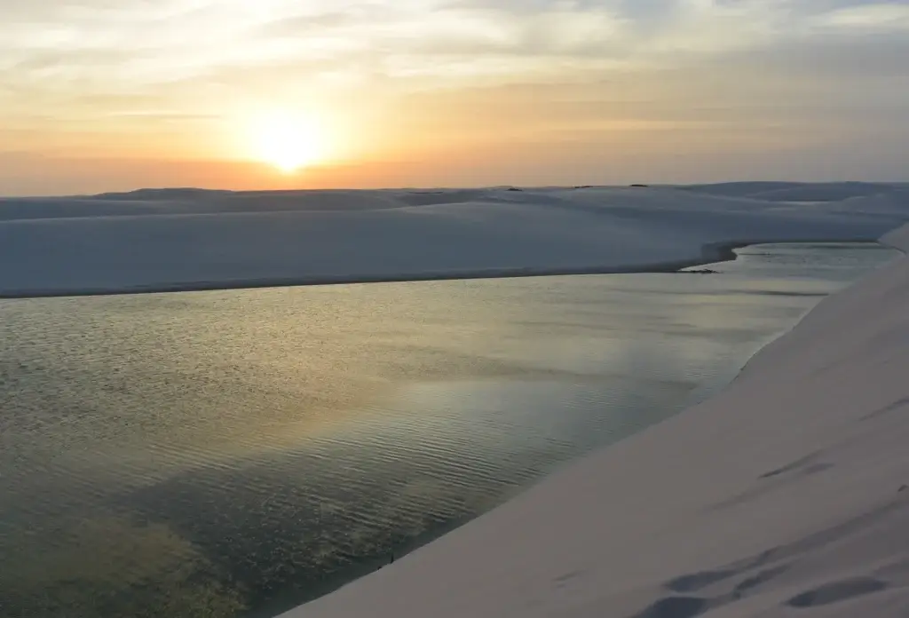 Sunset over a lagoon and dunes in Lençóis Maranhenses, Brazil.
